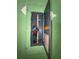 Electrical panel in a green room, with an open door showing electrical circuits at 1812 Firwood Ct, Orlando, FL 32818