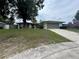Charming single-story home with a two-car garage, mature trees, and a spacious front yard at 1812 Firwood Ct, Orlando, FL 32818