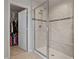Bathroom featuring glass enclosed shower, tiled walls and a corner bench seat with a view into the walk-in closet at 2168 Aibonito Cir, Clermont, FL 34711