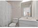 Well-lit bathroom with a white sink vanity, toilet, and shower with a white curtain at 2168 Aibonito Cir, Clermont, FL 34711