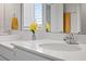 Bright bathroom with a double vanity featuring white cabinets, quartz countertops, and modern chrome faucets at 2168 Aibonito Cir, Clermont, FL 34711