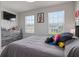 Bedroom with natural light and playful decor featuring a TV and a comfortable bed with plenty of pillows at 2168 Aibonito Cir, Clermont, FL 34711