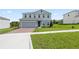 Inviting two-story home with a manicured lawn and brick driveway provides a warm, suburban feel at 2168 Aibonito Cir, Clermont, FL 34711