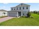 Elegant two-story home with brick driveway and verdant lawn, offers a picturesque suburban setting at 2168 Aibonito Cir, Clermont, FL 34711