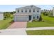 Charming two-story home with a brick driveway and well-manicured lawn offers a welcoming curb appeal at 2168 Aibonito Cir, Clermont, FL 34711
