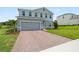 Beautiful two-story home featuring a brick driveway and lush lawn creates a stunning exterior view at 2168 Aibonito Cir, Clermont, FL 34711