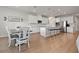 Open-concept kitchen and dining area with white cabinets, granite countertops and wood floors at 2168 Aibonito Cir, Clermont, FL 34711