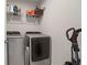 Laundry room with modern appliances including a washer, dryer, shelving, and cleaning supplies at 2168 Aibonito Cir, Clermont, FL 34711