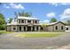 A gorgeous two-story home with a metal roof, dark trim, and circular driveway at 2459 Mcgregor Oaks Ln, Deland, FL 32720