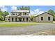 A gorgeous two-story home with a metal roof, dark trim, and lovely landscaping at 2459 Mcgregor Oaks Ln, Deland, FL 32720