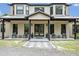 Inviting home with a covered front entrance, featuring sleek seating arrangements and modern decor at 2459 Mcgregor Oaks Ln, Deland, FL 32720