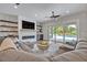 A spacious living room features a modern fireplace, ample seating, and sliding glass doors to the pool at 2459 Mcgregor Oaks Ln, Deland, FL 32720