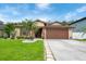 Charming single-story home featuring a well-manicured lawn and a beautiful palm tree accenting the front yard at 2625 Eagle Cliff Dr, Kissimmee, FL 34746