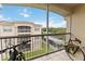 Screened balcony view of building and grounds featuring plants and bicycles with tile flooring at 3000 Laurel Park Ln # 308, Kissimmee, FL 34741