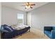 A blue bedroom featuring a ceiling fan, carpet flooring, and natural light at 3000 Laurel Park Ln # 308, Kissimmee, FL 34741