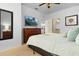 Bedroom showing queen bed, wooden dresser with TV, and open bathroom doorway at 3203 Oyster Ln, Kissimmee, FL 34747