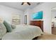 Bright bedroom featuring large bed, wood dresser with TV, and plenty of natural light at 3203 Oyster Ln, Kissimmee, FL 34747