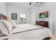 Bright bedroom showcasing a queen bed, wood dresser with a large TV, and a view of outside at 3203 Oyster Ln, Kissimmee, FL 34747