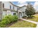 Two-story townhouse featuring lush landscaping, healthy green lawn, and mature shade trees at 3203 Oyster Ln, Kissimmee, FL 34747