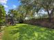 Spacious backyard with green grass and tropical trees features a screened pool and hot tub at 3307 Kentshire Blvd, Ocoee, FL 34761