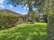 The backyard features a green lawn, tropical trees, and a screened pool with a hot tub at 3307 Kentshire Blvd, Ocoee, FL 34761