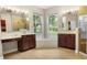 Bathroom featuring dual vanities, a soaking tub under a large window, and a glass-enclosed shower at 3307 Kentshire Blvd, Ocoee, FL 34761