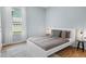 Cozy bedroom with a white platform bed, neutral bedding, and natural light from a window at 3307 Kentshire Blvd, Ocoee, FL 34761