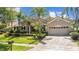 Charming single-story home featuring a two car garage, tiled roof, lush landscaping, and a paved driveway at 3307 Kentshire Blvd, Ocoee, FL 34761