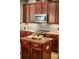 Kitchen features stainless steel appliances, tile backsplash, island, and dark wood cabinetry at 3307 Kentshire Blvd, Ocoee, FL 34761