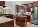 Kitchen with stainless steel refrigerator, mosaic tile backsplash, wooden cabinets, and a kitchen island at 3307 Kentshire Blvd, Ocoee, FL 34761