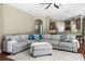 Open-concept living room features a large sectional sofa, wood floors, and seamless access to the kitchen at 3307 Kentshire Blvd, Ocoee, FL 34761