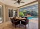 Covered patio featuring a ceiling fan and outdoor dining set overlooking a screened-in pool and hot tub at 3307 Kentshire Blvd, Ocoee, FL 34761