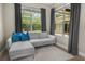 Cozy sitting area features a modern sofa, bright pillows, and two large windows at 3307 Kentshire Blvd, Ocoee, FL 34761