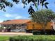 A bright yellow train car in front of the building with a tiled roof adds a whimsical touch to the historical site at 3307 Kentshire Blvd, Ocoee, FL 34761