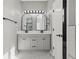 Bright bathroom featuring a double sink vanity with arched mirrors and modern lighting at 3824 Blue Dasher Dr, Kissimmee, FL 34744