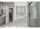 Spacious bathroom with a soaking tub under a window and a glass-enclosed shower at 3824 Blue Dasher Dr, Kissimmee, FL 34744