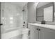 Bathroom featuring modern fixtures, marble tile, and a bathtub with a shower at 3824 Blue Dasher Dr, Kissimmee, FL 34744