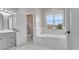 Elegant bathroom featuring a soaking tub, tiled floors and walls, and a modern vanity, enhancing its luxurious appeal at 3824 Blue Dasher Dr, Kissimmee, FL 34744