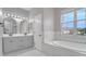 Elegant bathroom featuring a soaking tub and modern vanity with stylish mirrors, enhancing its luxurious appeal at 3824 Blue Dasher Dr, Kissimmee, FL 34744