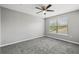 Bright bedroom with neutral walls, carpet, ceiling fan, and a window at 3824 Blue Dasher Dr, Kissimmee, FL 34744