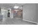 Spacious living area with elegant lighting, open to the kitchen, and wood look floors at 3824 Blue Dasher Dr, Kissimmee, FL 34744