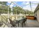 Screened patio area with seating, dining, and hot tub at 3824 Blue Dasher Dr, Kissimmee, FL 34744