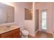 Bathroom featuring tile floor, toilet, cabinet with sink and enclosed shower and a door to the outside at 3904 Coastal Breeze Dr, Kissimmee, FL 34744