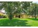 Lush lawn and mature trees highlight this home's exterior with a covered patio at 3904 Coastal Breeze Dr, Kissimmee, FL 34744