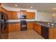 Bright kitchen showcasing wooden cabinets, granite counters, and black appliances at 3904 Coastal Breeze Dr, Kissimmee, FL 34744