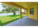 Covered patio overlooking serene lake with lush green lawn and mature trees at 3904 Coastal Breeze Dr, Kissimmee, FL 34744