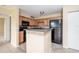 Compact kitchen with stainless steel appliances, breakfast bar, and neutral-toned cabinets at 420 Forestway Cir # 206, Altamonte Springs, FL 32701