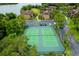 Aerial view of community tennis courts surrounded by mature trees, parking and community buildings near the water at 420 Forestway Cir # 206, Altamonte Springs, FL 32701