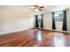 Bedroom with hardwood floors, two windows with dark curtains, and white trim at 4300 Lake Underhill Rd # D, Orlando, FL 32803