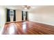 Bright bedroom with ceiling fan, hardwood floors, and large windows with dark curtains at 4300 Lake Underhill Rd # D, Orlando, FL 32803
